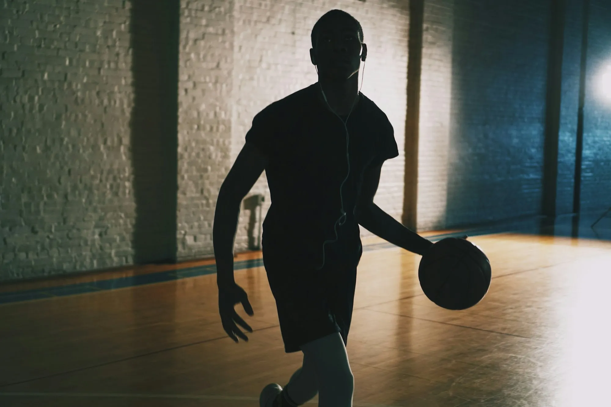 A player dribbling in an empty gym