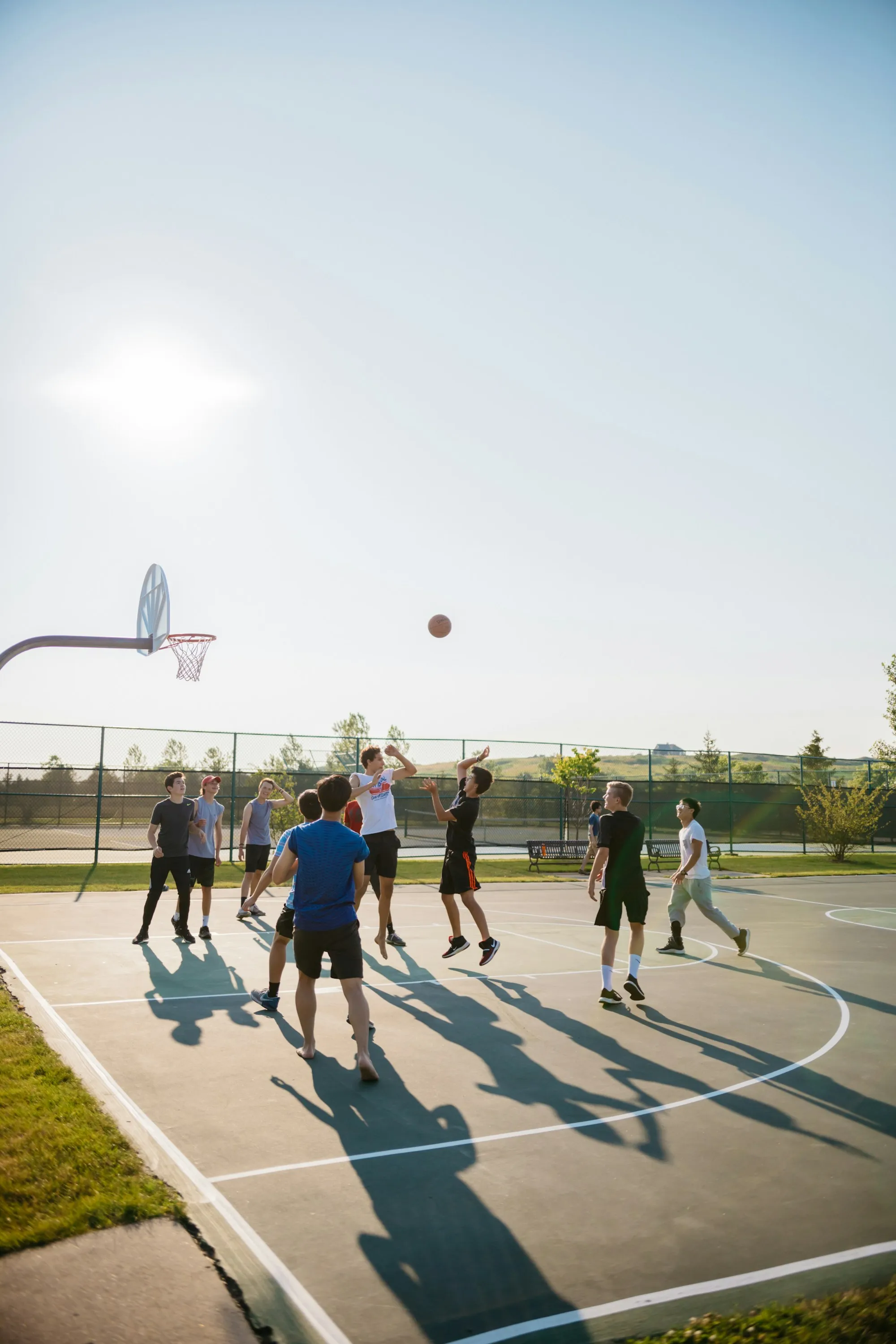 A pickup game on an outdoor court at golden hour